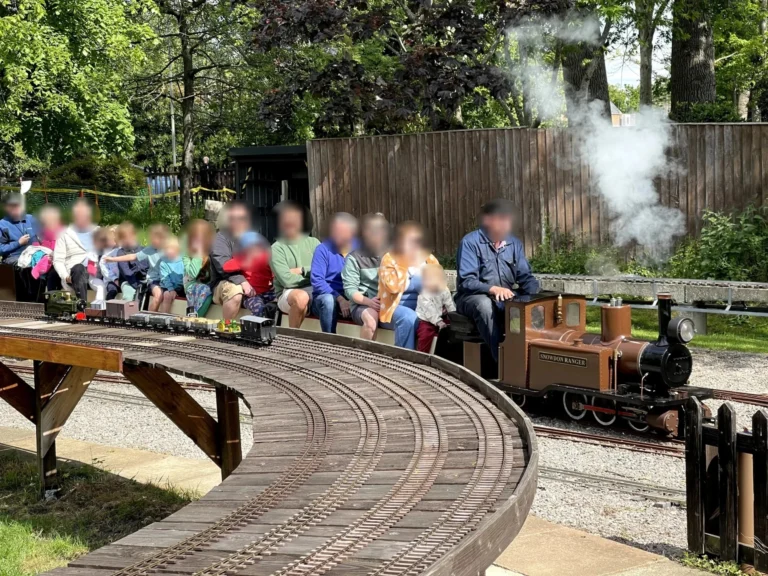Passengers riding the miniature steam train at the Cheltenham Society of Model Engineers
