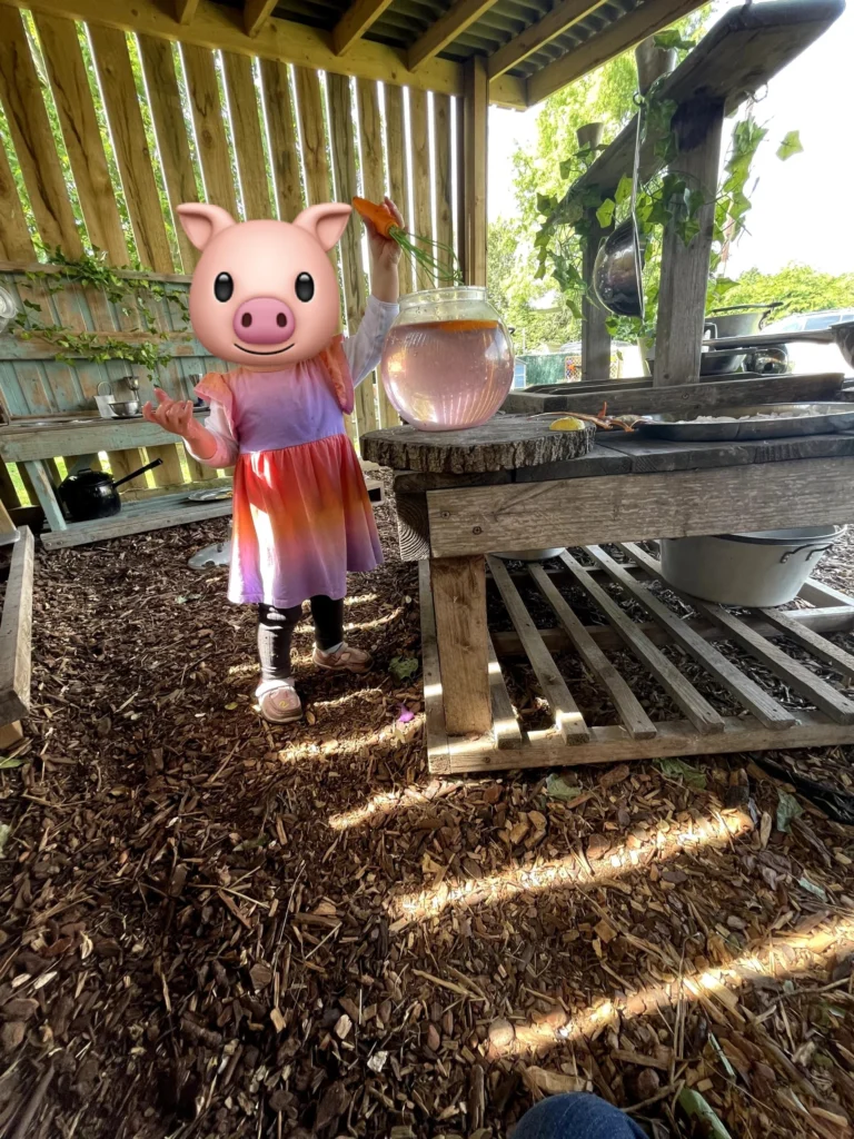 A child in the covered mud kitchen at Little Hedgehogs Play Garden