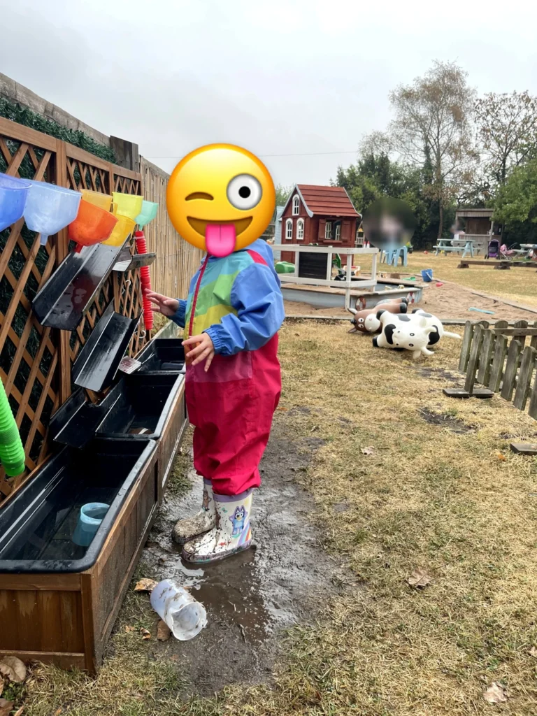 A toddler at the water play wall at Little Hedgehogs Play Garden