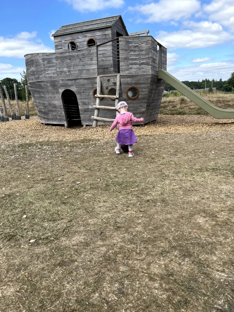 A toddler by the wooden play fort at The Orchard Coffee House