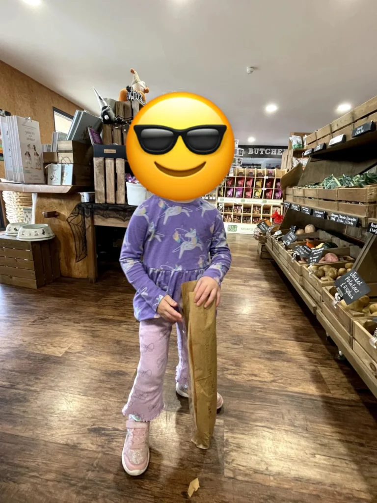 A child on a wooden rocking horse in the shop at Court Farm Shop