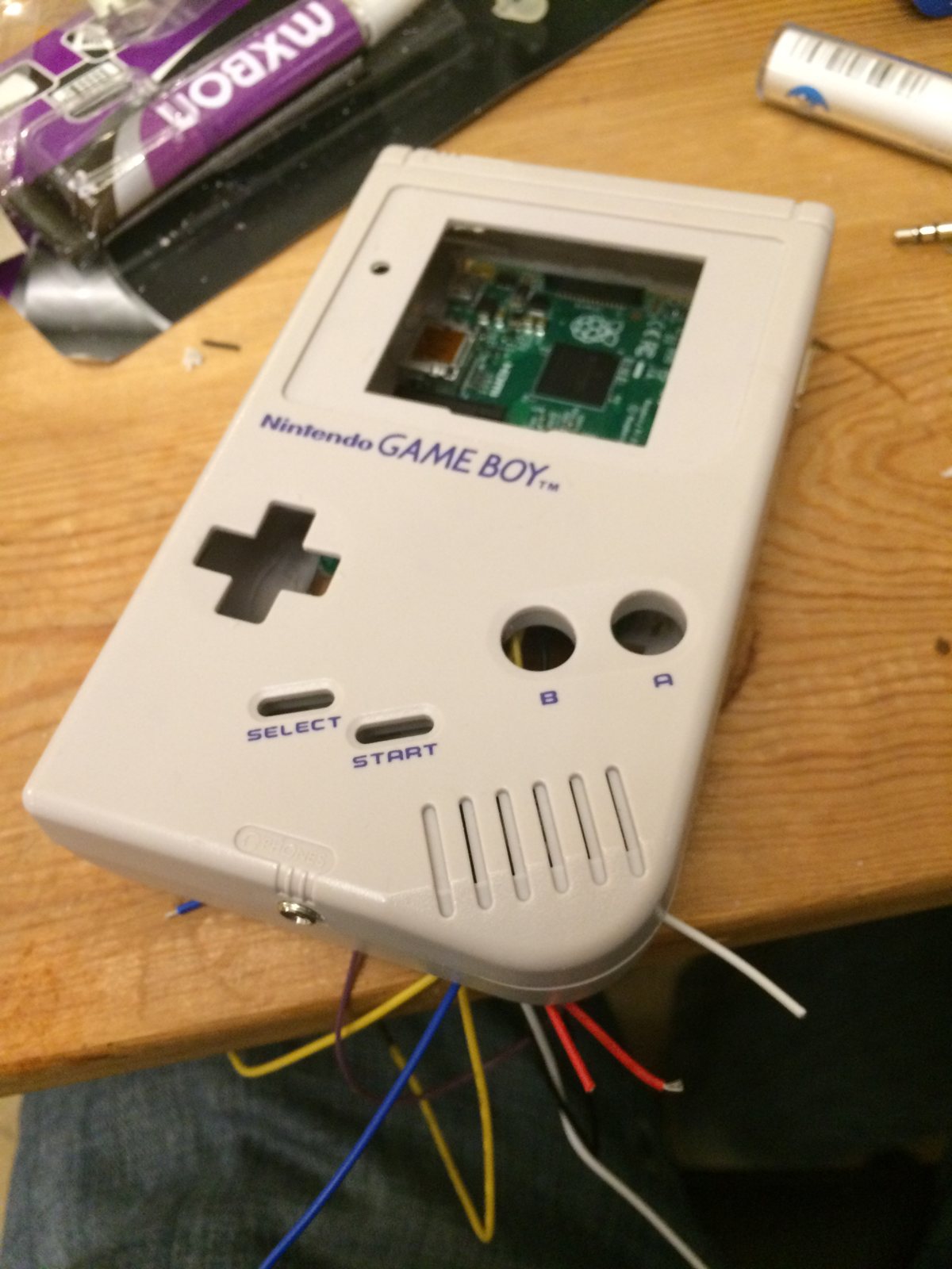 The front case with the screen window cut and wires trailing out