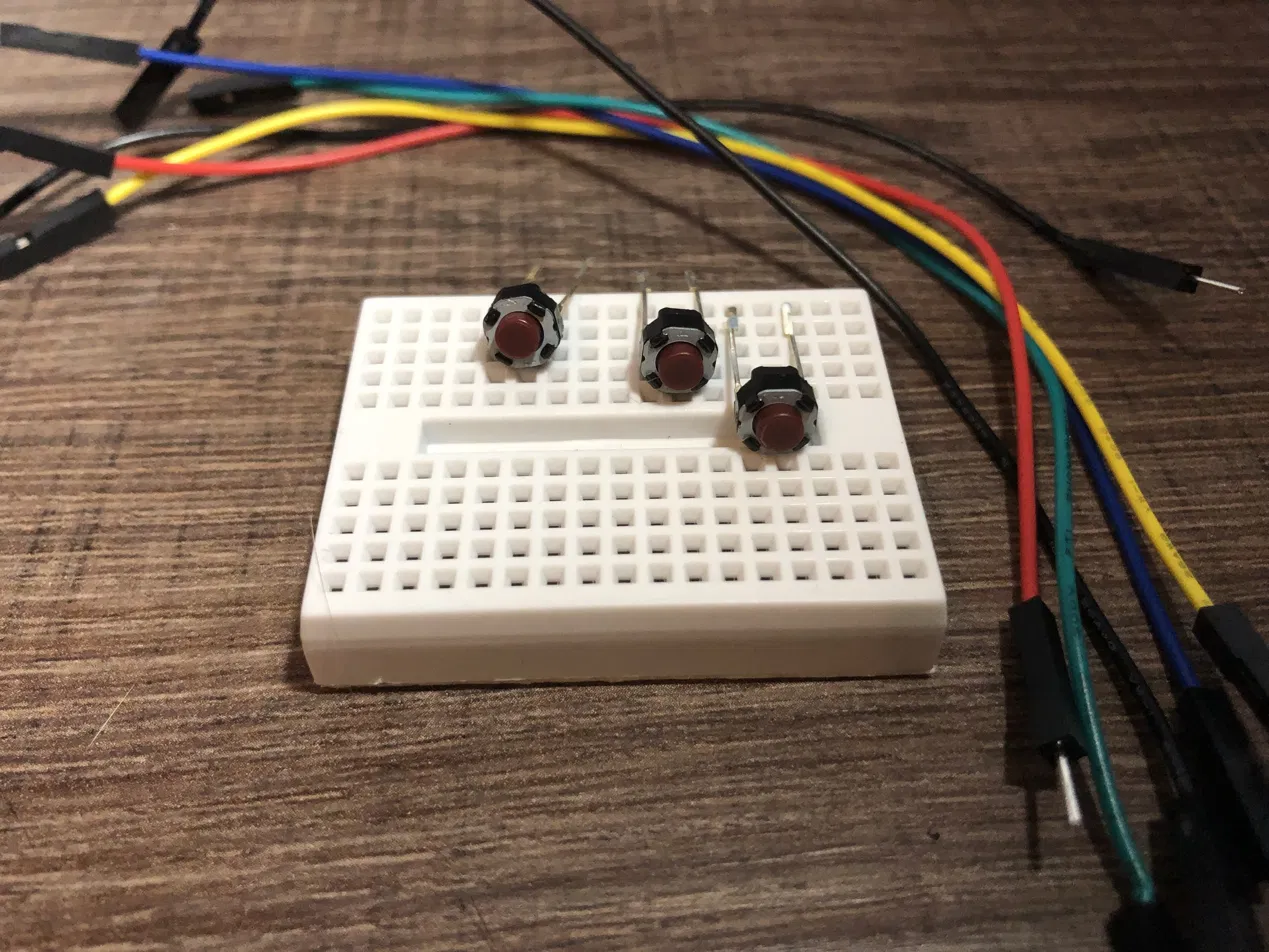 All three push buttons in place on the mini breadboard, jumper leads ready