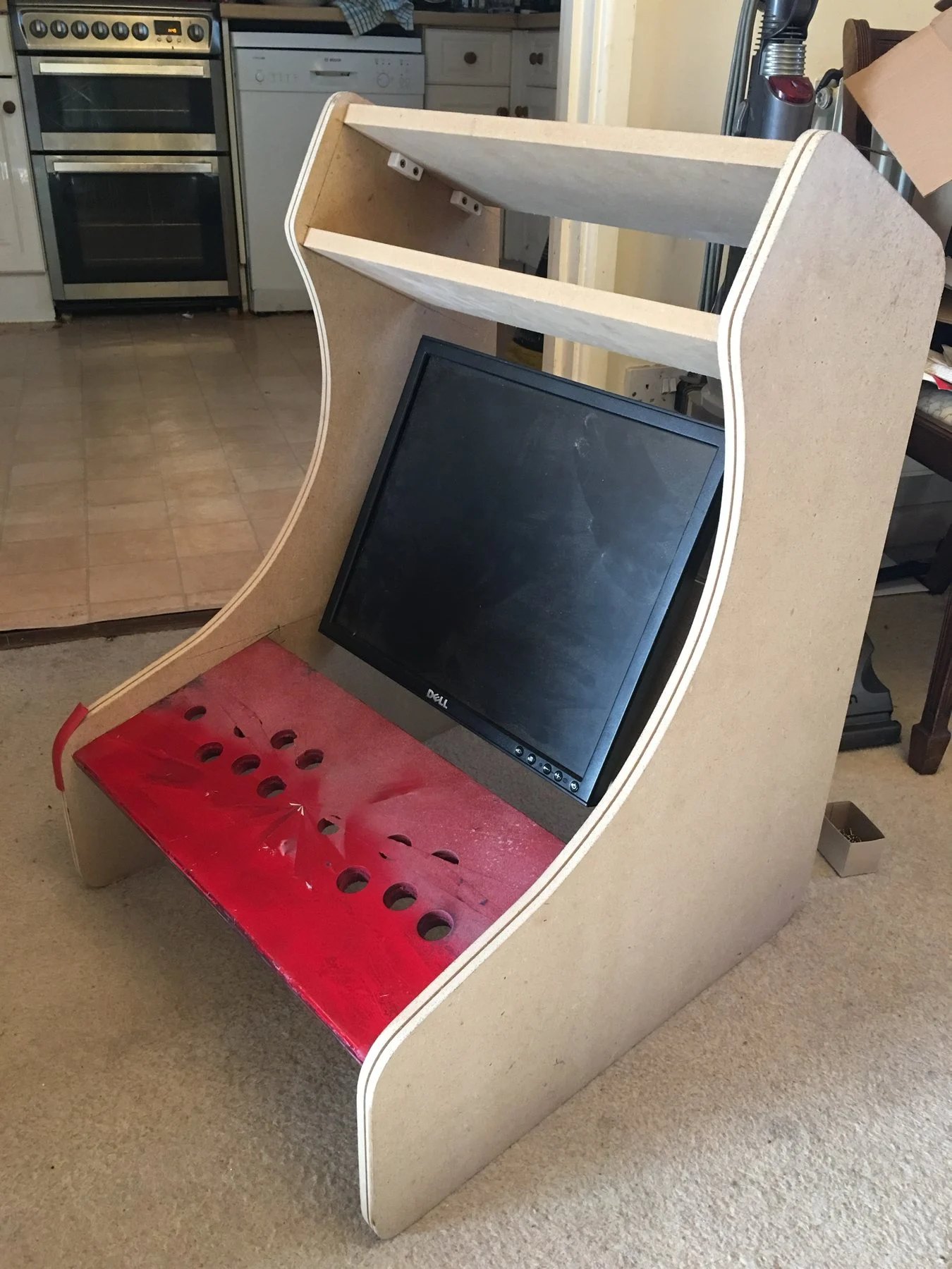 The cabinet with the monitor and red control panel test fitted